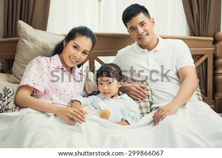 Asian family Teaching children to read books in bed