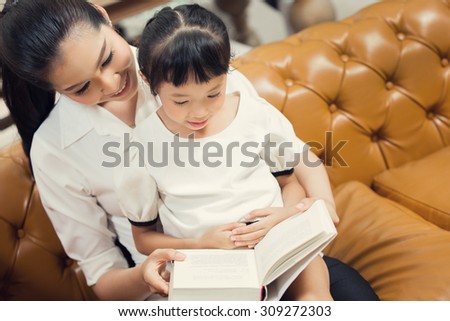 Mom teaching daughter to read at home