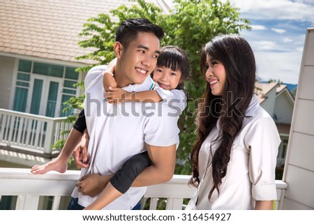 Asian family daughter, riding behind his father as a happy family
