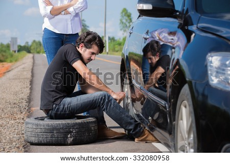 Man changing tire That are leaking His car broke down en route to the girlfriend