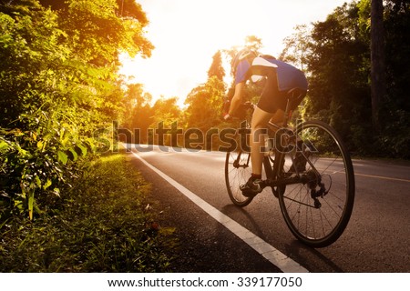 Female cyclist cycling am The path in the woods and mountains