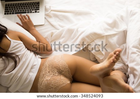 Women using laptop and wearing her sexy relaxed at her bed. Top view