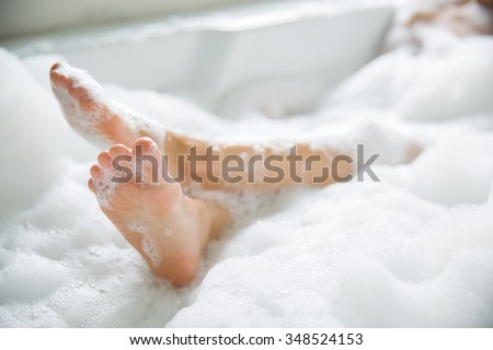 Women\'s feet she was bathing in a a bathtub with happiness