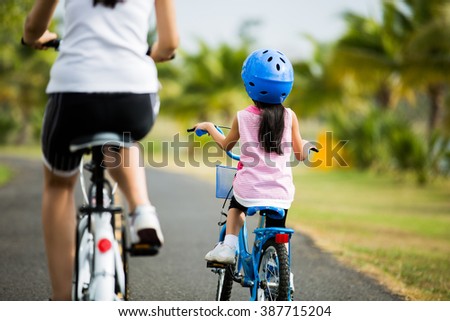 Mother and son are cycling in the park.