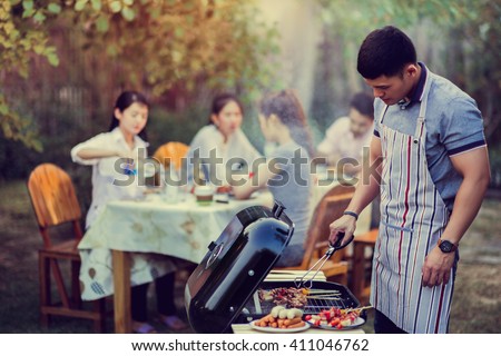 Asian men are cooking a barbecue for friends