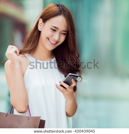 Asian women are shopping department store.she was on the phone to check stock