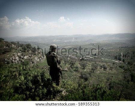 NABLUS, ISRAELI OCCUPIED TERRITORIES IN THE WEST BANK - 24, APRIL, 2007: An Israeli soldier with the Israeli Defense Forces overlooks the hills around Nablus while being on patrol.