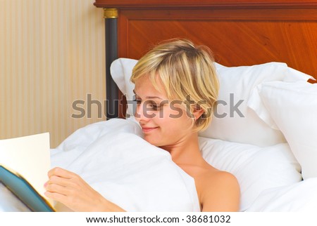 Young blonde woman choosing from the menu in a hotel room