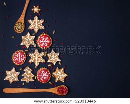 christmas tree made from gingerbread cookies and wooden spoons with spices on dark blue background with copy space for text. holiday, celebration and cooking concept. new year and christmas postcard