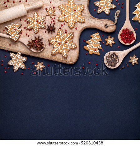 traditional christmas homemade gingerbread cookies, spices and cutting board on dark blue background. holiday, celebration and cooking concept. new year and christmas postcard. flat lay, top view