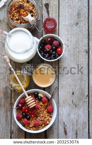 Healthy breakfast with granola, berries, milk, honey and coffee, selective focus, space for text