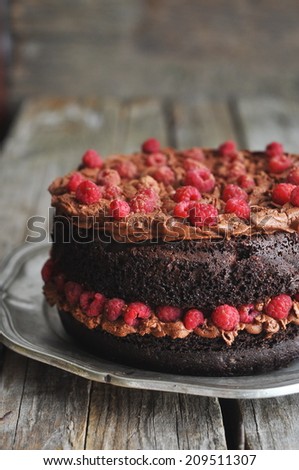 Chocolate cake with chocolate whipped cream and raspberries, selective focus
