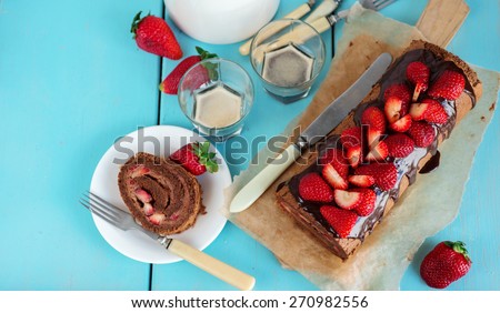 Chocolate Swiss roll or roulade with strawberries from above, selective focus