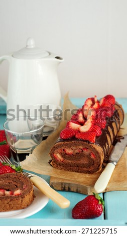 Chocolate Swiss roll or roulade with strawberries, selective focus