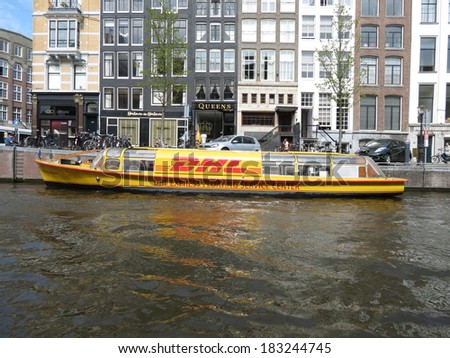 AMSTERDAM, CIRCA APRIL 2013 - DHL post company boat delivering mail in the city centre of Amsterdam, circa April 2013