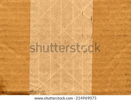 brown corrugated cardboard sheet with adhesive tape useful as a background