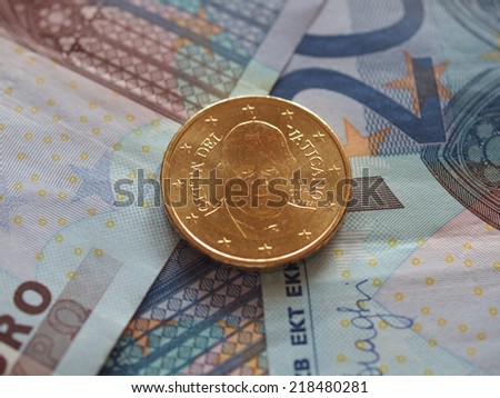 Twenty Euro (EUR) banknotes useful as a background or money concept - with a Fifty Euro coin from Vatican bearing the portrait of Pope Bergoglio Francis I