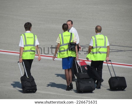 VIENNA, CIRCA SEPTEMBER 2014 - Ryan Air staff carrying their trolley on the runway towards the aircraft