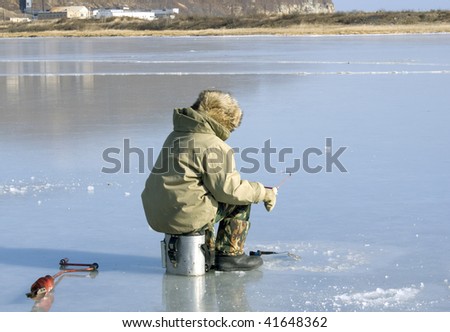 fisherman caughts fishing rod fish from under ice
