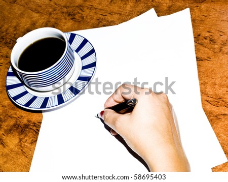 Woman writing on paper during coffee break