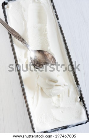 Homemade vanilla ice cream in frozen metallic container.