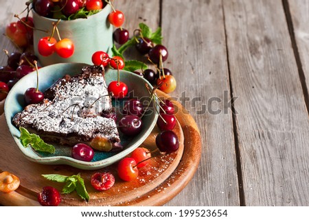 Chocolate clafoutis with ripe cherry on iron pan with fresh mint and sugar powder. Selective focus. Copy space background.