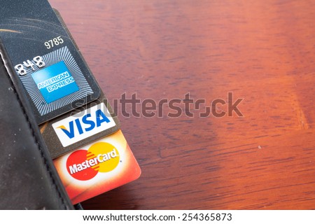 PAHANG , MALAYSIA - FEBRUARY 21, 2015 - Illustrative Editorial,close up of credit cards , master card, VISA and american express in the leather wallet with wood background, product shot