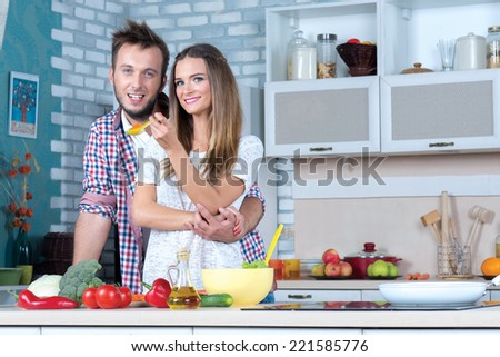 Cooking at home. Young and beautiful couple in love is staying in the kitchen and cooking dinner for romantic evening