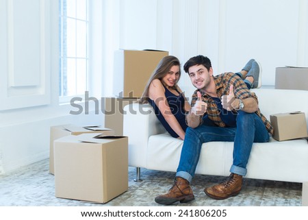 Moving new house is well done. Young and beautiful couple is moving to new apartment surrounded with plenty of cardboard boxes.