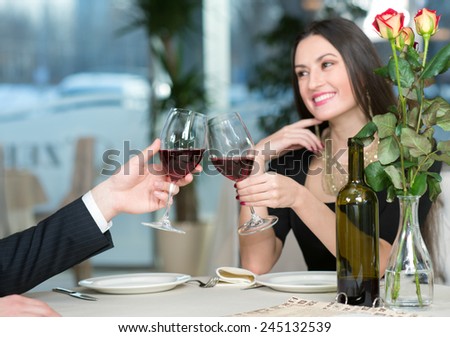 Close up of wine glasses and beautiful girl having romantic evening in restaurant with her beloved husband