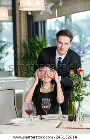 Portrait of handsome man spending time in restaurant with his wife. He is prepared to give present for his beloved wife