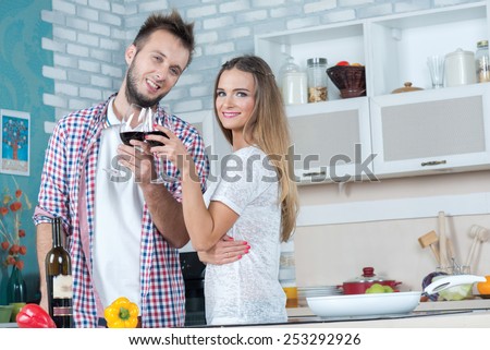 Food wine and love. Young and beautiful couple in love is drinking wine on the kitchen while preparing food on the kitchen. Diet. Healthy vegetarian food