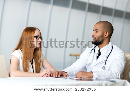 Meeting physician with the patient. Doctor is talking with the patient while sitting at a table in the hospital. Healthy approaches.