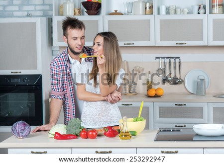 Best cooking food for lovers. Young and beautiful couple in love is preparing food in the kitchen while tasting some food
