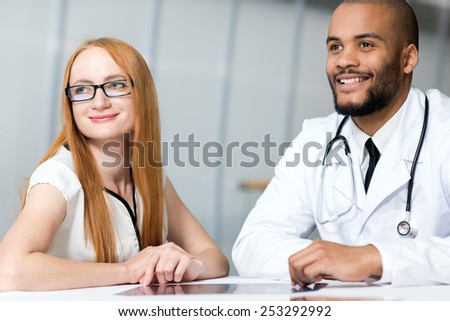 Meeting physician with the patient. Doctor is talking with the patient while sitting at a table in the hospital. Healthy approaches.