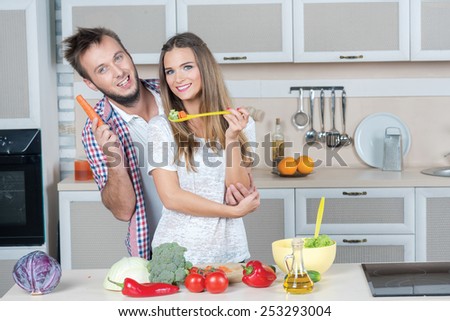 Best cooking food for lovers on the kitchen. Young and beautiful couple in love is preparing food in the kitchen while tasting some food