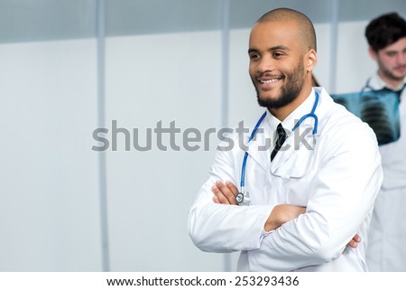 Portrait of a doctor of the therapist. Confident doctor is standing in the hospital in a white coat. Smiling and thinking about patient and health