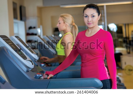 Good workout. Portrait of young and pretty sports girl. Sportswoman is standing on treadmill