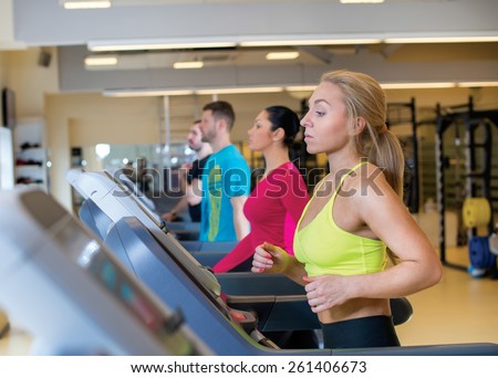 Good workout. Portrait of young and pretty sports girl. Sportswoman is running on treadmill