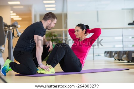 Intensive abs training together. Couple of young and beautiful people is having workout in a gym. Perfect shape. Sportsmen. Body workout together.