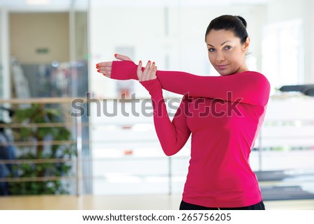 Intensive female training together. Portrait of young and beautiful girl in a gym. Girl is doing stretching in a gym. Perfect shape. Sportsmen.