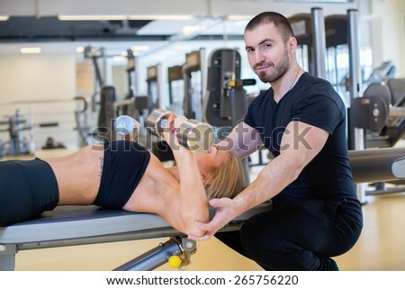 Intensive training together. Couple of young and beautiful people is having workout in a gym. Perfect shape. Sportsmen. Hard workout in a gym. Athlete people