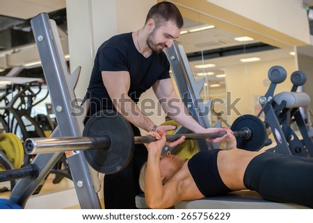 Intensive training together. Couple of young and beautiful people is having workout in a gym. Perfect shape. Sportsmen. Hard workout in a gym