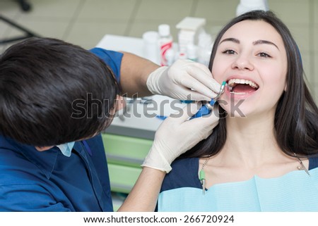 Healthy teeth and dental healthcare. Confident professional doctor dentist is working with pretty female patient. Doctor stomatologist is wearing medical clothing. Stomatology concept
