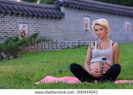 Perfect pregnant yoga. Portrait of young and beautiful woman making yoga in the nature. Pregnant yoga outdoor concept