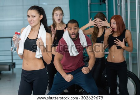 Intensive female training together with group. Young and beautiful woman is having workout in a gym. Perfect healthy shape. Sportsmen. Good workout in a gym