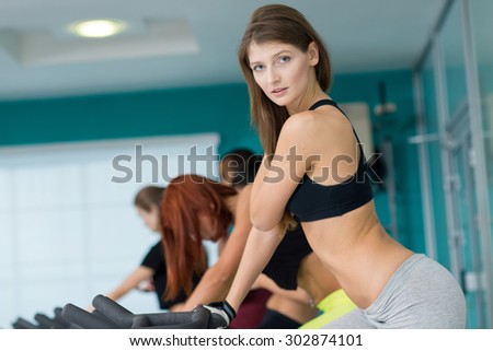 Perfect shape in a gym. Young and beautiful girl is having training on a exercise bike.. Active workout. Healthy sportsmen concept