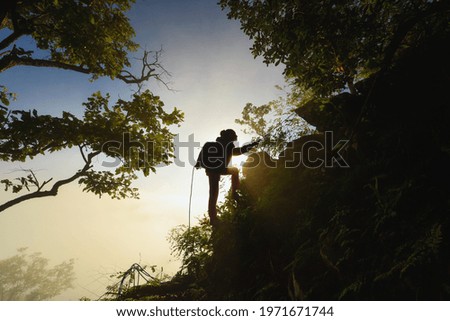 female hiker on top hills with arms out durin sunrise,cheering woman hiker open arms at mountain peak