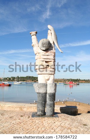 ALVOR, PORTUGAL-NOVEMBER 2 2013. Modern stone statue of a fisherman on the waterfront at Alvor, Portugal on November 2 2013.
