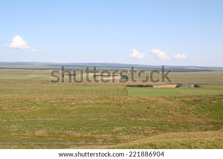 Panoramic view over Northumbrian farmland in the North of England, Poor Quality grassland for livestock and remote farms with sparse trees for windbreaks stretch into the distance.